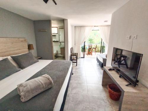 a bedroom with a bed and a flat screen tv at Tierra Maravilla in Salento