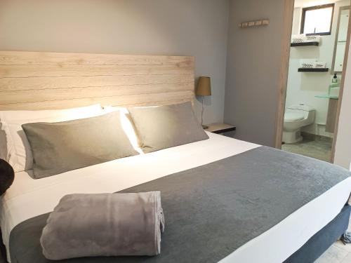 a bedroom with a large white bed and a toilet at Tierra Maravilla in Salento