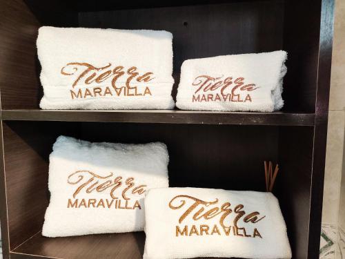 a shelf with three white towels with marrakka at Tierra Maravilla in Salento