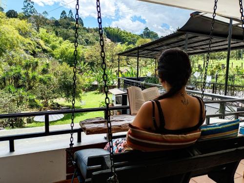 a woman sitting on a swing looking out of a window at Tierra Maravilla in Salento