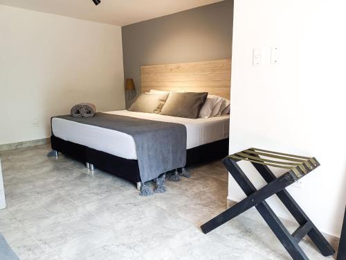 a bedroom with a bed with a wooden headboard and a stool at Tierra Maravilla in Salento