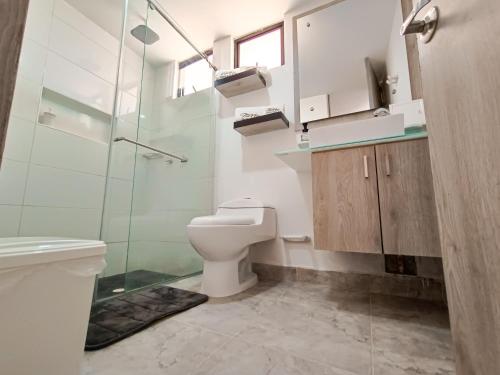 a bathroom with a toilet and a glass shower at Tierra Maravilla in Salento