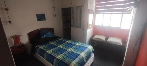 1 dormitorio con cama y ventana en Habitación individual, baño compartido, en Santiago