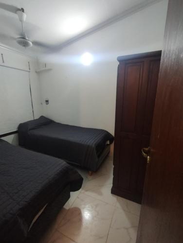 Habitación pequeña con 2 camas y puerta en Casa la bendecida II en Santiago del Estero