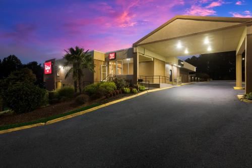 a empty parking lot outside of a hotel at night at Red Roof Inn Atlanta Airport NE Conley in Conley