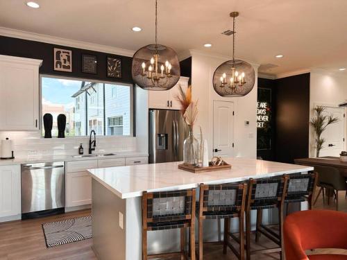 a kitchen with a large island with bar chairs at The Oasis Checkmate Stunning Rooftop with Views in Houston