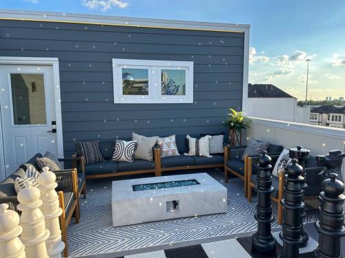 a patio with a couch and a coffee table at The Oasis Checkmate Stunning Rooftop with Views in Houston