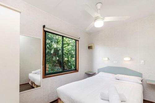 a bedroom with a white bed and a window at Portland Holiday Village in Portland