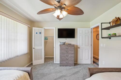 a bedroom with a ceiling fan and a television at Luxurious Florida Home with Pool and Canal Access in Indian Lake Estates