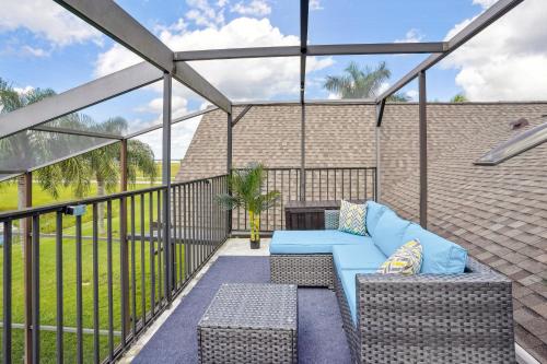 a screened in porch with a blue couch at Luxurious Florida Home with Pool and Canal Access in Indian Lake Estates