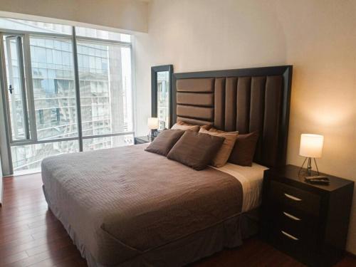 a bedroom with a large bed and a large window at High-Rise Reforma Apartment , 2BDR, 2BATH, in Mexico City