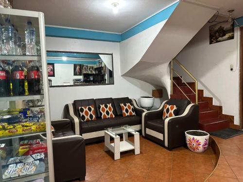 a living room with two couches and a staircase at Hospedaje Qorichaska's in Cusco