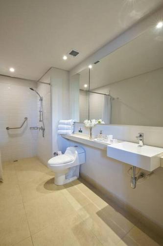 uma casa de banho com um WC, um lavatório e um espelho. em caluce hab 403 by letoh em Chía