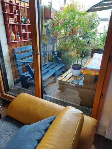 a couch sitting in front of a sliding glass door at Stade de France Chambre d'Hôte by RESERVATI HOME in Saint-Denis