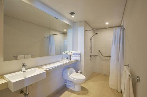 uma casa de banho com um lavatório, um WC e um espelho. em caluce hab 405 by letoh em Chía
