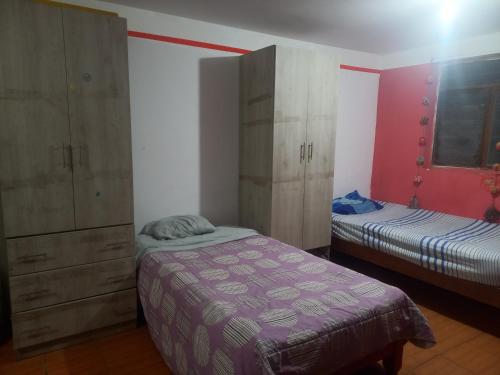 een slaapkamer met 2 aparte bedden en een kast bij MyD in Cuzco