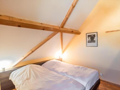 a bedroom with a white bed in a attic at Lac Bleu 26 in Lacapelle-Marival