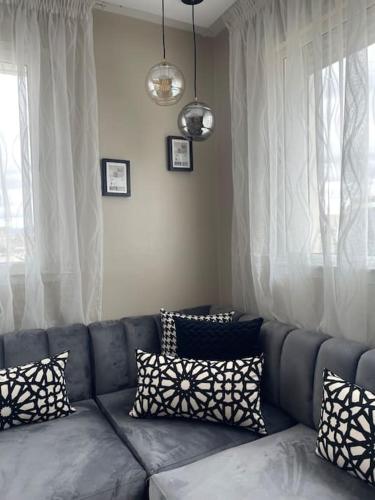 a couch with pillows on it in a living room at Chic & cosy appartement au centre d’Oujda in Oujda