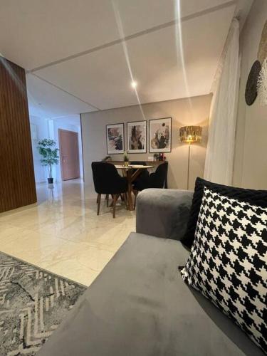 a living room with a couch and a dining room table at Chic & cosy appartement au centre d’Oujda in Oujda