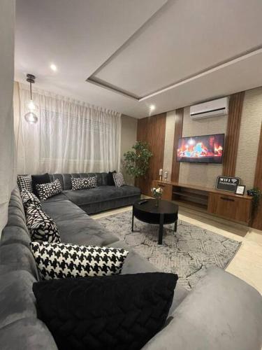 a living room with a couch and a tv at Chic & cosy appartement au centre d’Oujda in Oujda