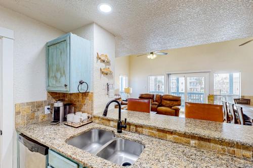 een keuken met een wastafel en een woonkamer bij Ladyfish Landing in Padre Island