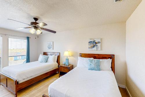 1 dormitorio con 2 camas y ventilador de techo en Ladyfish Landing en Padre Island