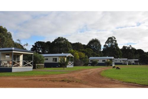 a dirt road in front of houses and a field at Discovery Parks - Kangaroo Island in Flinders Chase