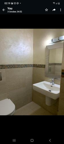 een badkamer met een wastafel, een toilet en een spiegel bij Luxry apartment in Abdoun. Amman, jordan in Amman