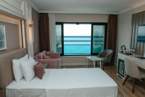 a hotel room with a bed and a view of the ocean at Vira Otel Suites in Sinop
