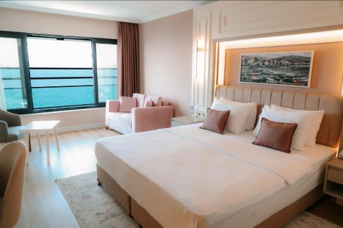 a bedroom with a large bed and a living room at Vira Otel Suites in Sinop