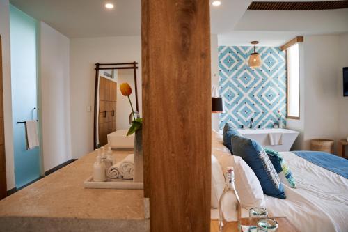 a bedroom with a large bed and a mirror at Hotel Basalto in Punta Mita