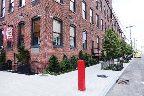 a red pole in front of a brick building at Henry Norman Hotel in Brooklyn
