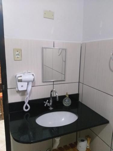 a bathroom with a sink and a phone at Casa Do Roger Hospedagem in Ouro Preto