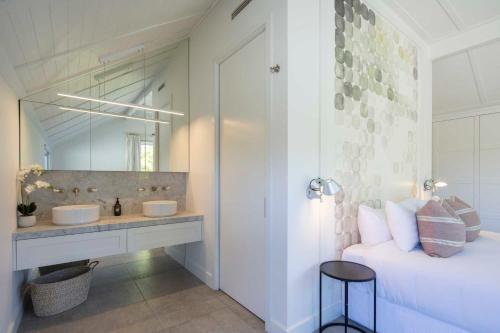 a bathroom with two sinks and a bed and a mirror at Arrow Wood - Minutes to Arrowtown, Golf and Wineries - Luxury Living in Arrowtown