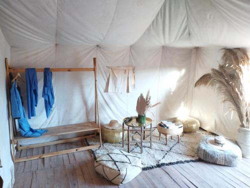 a room with a bed and a table in a tent at Saba Berber Travel in Mhamid