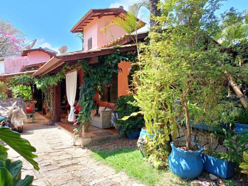 een huis met bomen in potten ervoor bij Vila Santa Rosa in Ilhabela