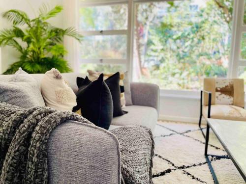 a living room with a couch and a window at Renovated charming & cozy house (Walk to Station) in Sydney