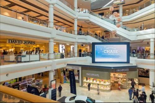 a shopping mall with a large screen in the middle at Renovated charming & cozy house (Walk to Station) in Sydney