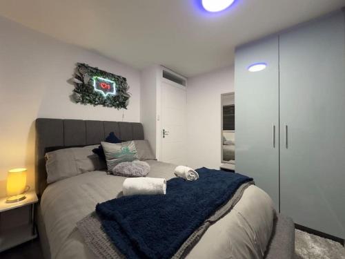 een slaapkamer met een bed met een blauwe deken erop bij Gorgeous Graceful Getaway w/ Gazebo - Tylorstown in Llwyn-y-pia