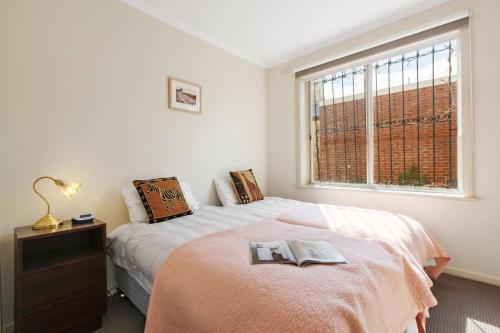 a bedroom with a bed with a dresser and a window at Northcote Charm Spacious and Quiet Suburban Stay in Melbourne