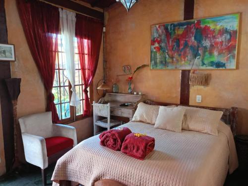 Un dormitorio con una cama con toallas rojas. en Vila Santa Rosa, en Ilhabela