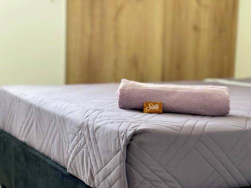 - une serviette rose assise au-dessus du lit dans l'établissement AG APTO con Aire Acondicionado, à Neiva