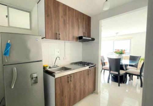een keuken met een koelkast en een tafel met stoelen bij AG APTO con Aire Acondicionado in Neiva