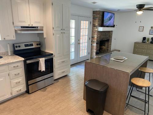 a kitchen with white cabinets and a stove top oven at Spacious Ranch Home Near Airport in Pensacola