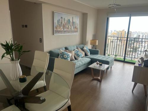 Una sala de estar con un sofá azul y una mesa. en Aparment Deluxe San Isidro, en Lima