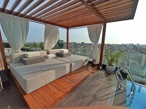 - une chambre avec un grand lit sur un balcon dans l'établissement Aparment Deluxe San Isidro, à Lima