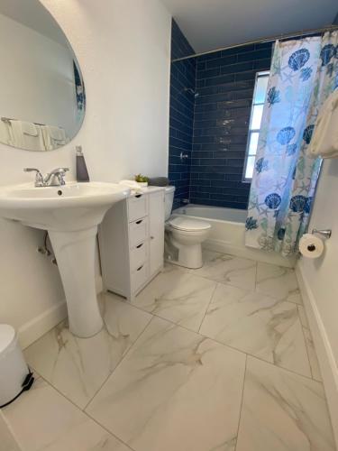 a bathroom with a sink and a toilet and a mirror at Spacious Ranch Home Near Airport in Pensacola