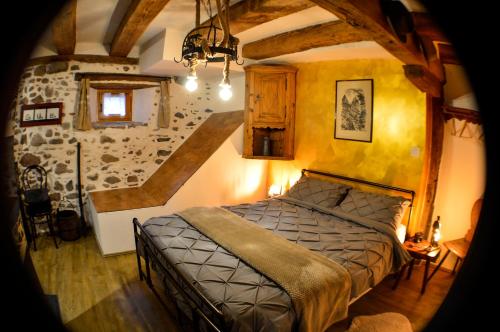 a bedroom with a bed and a stone wall at Chaud'Vin in Kaysersberg
