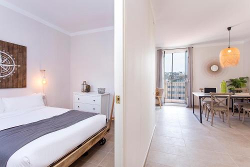 1 dormitorio con 1 cama y comedor con mesa en Stay U-nique Apartments Fira BCN III, en Hospitalet de Llobregat