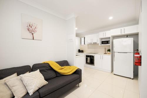 a living room with a couch and a kitchen at Air-Con, Netflix, Close to Transport & Private in Brisbane